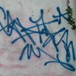 Graffiti bleu sur un mur blanc à Auray illustrant les enjeux de propreté urbaine